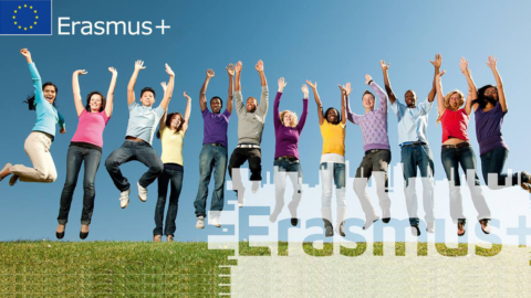 A diverse group of young adults is jumping joyfully in the air on a grassy field, under a clear blue sky. The photo is graphicly editted including word "Erasmus+" which is partially visible.