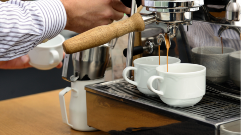 A bartender prepares two coffees